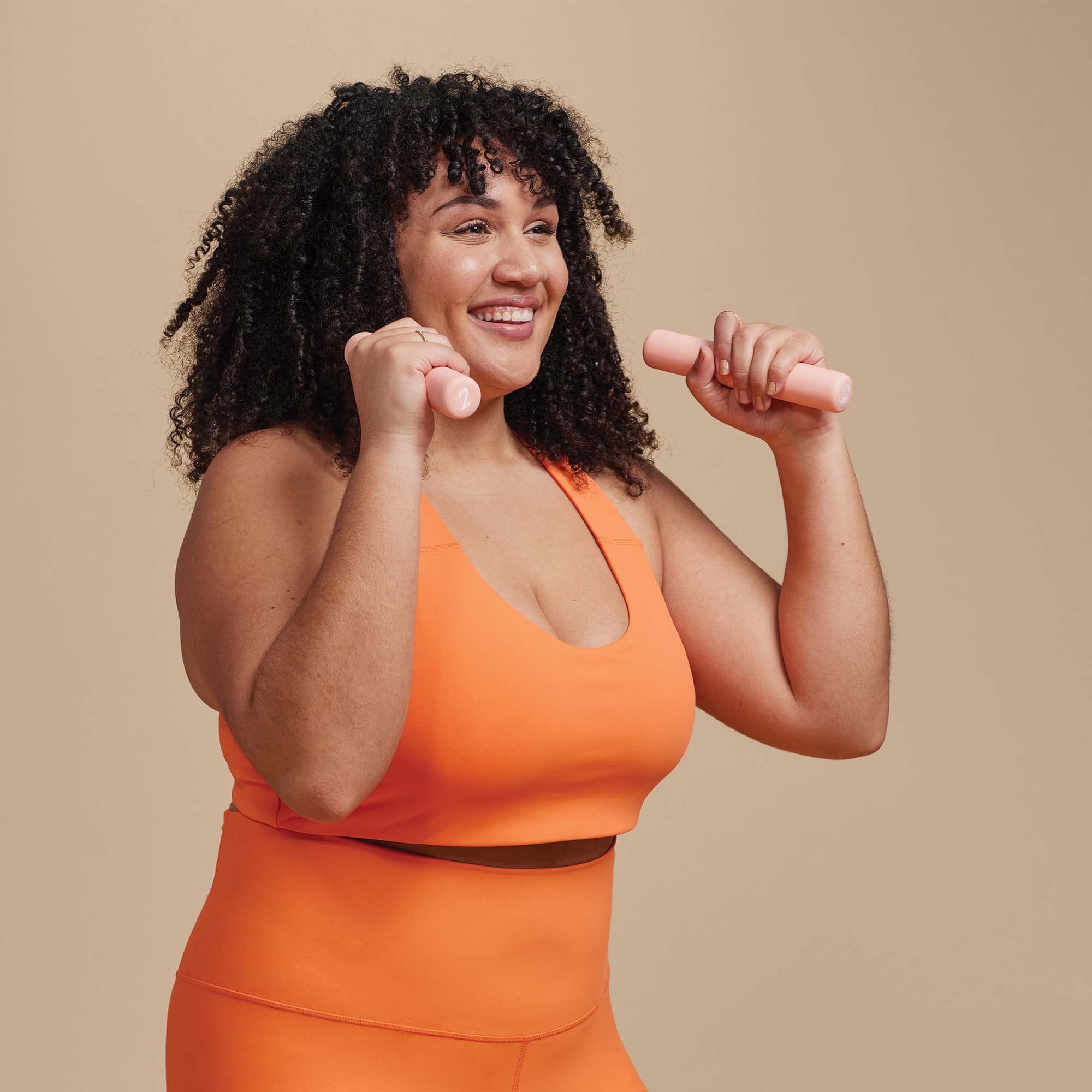 Person holding the POPSUGAR 2lb Bar Weights - one in each hand 